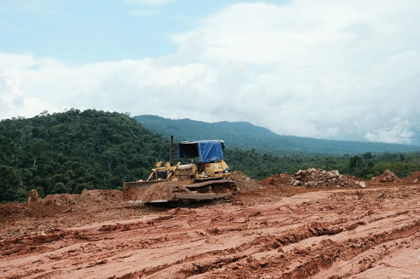Compact loader and worker beside a residential trench