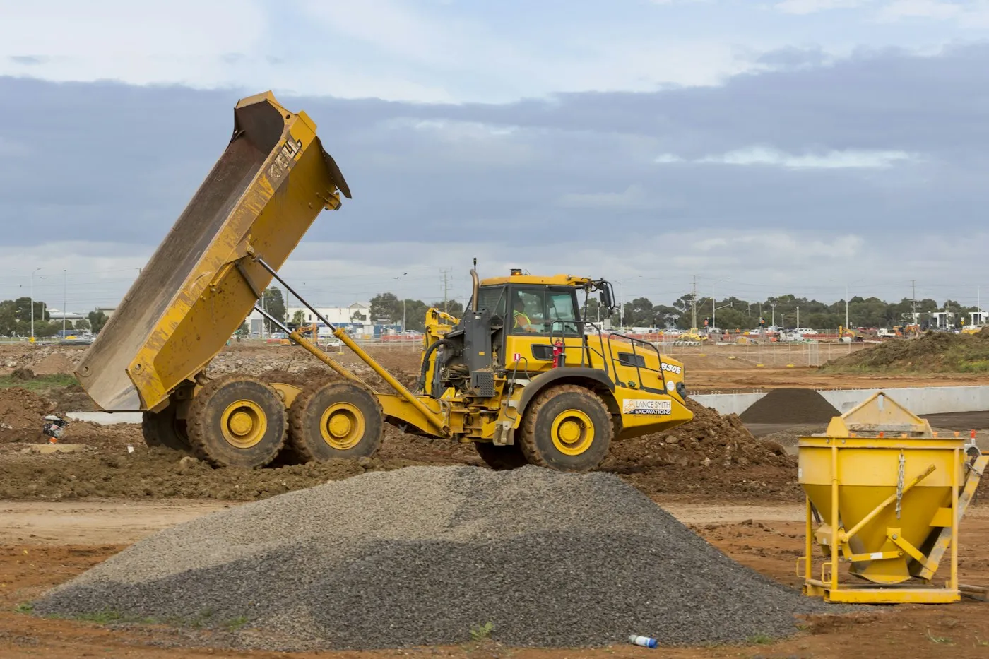 Haul truck tipping material at an earthwork site